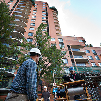 two men in hard hats by high rise